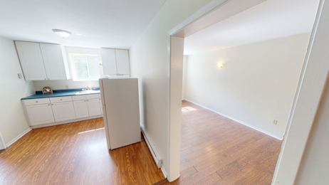 Floor Plan  A kitchen with white cabinets and a window.