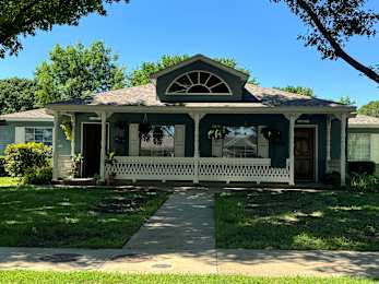 A house with a porch and a white fence.