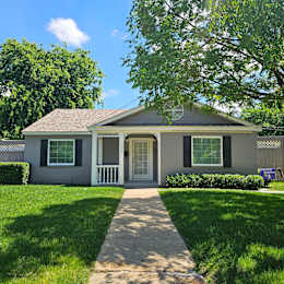 A small house with a grey roof and white trim.