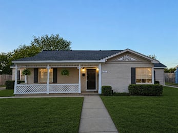 A small house with a porch and a front yard.