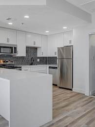 A modern kitchen with a white island and stainless steel appliances.