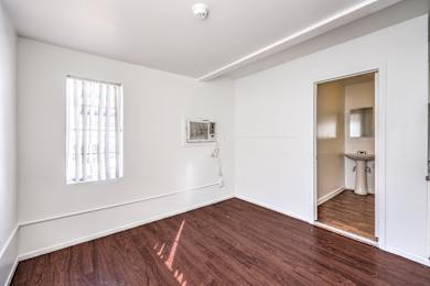 A room with a wooden floor and a window.