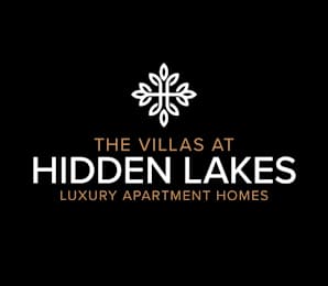 The image is a logo for The Villas at Hidden Lakes, a luxury apartment home.
