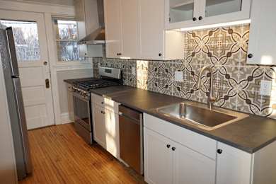 A kitchen with white cabinets and a tile backsplash.