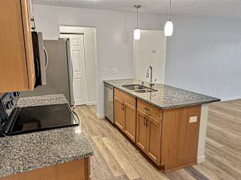 A kitchen with granite countertops and wooden cabinets.