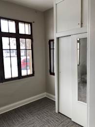 A white door is open to a room with a grey carpet.