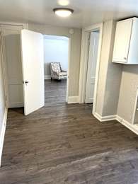 A room with white doors and a grey chair.
