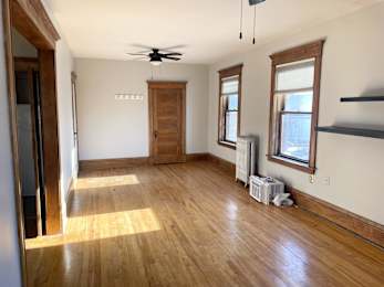 A room with wooden floors and a ceiling fan.