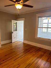 A room with a ceiling fan and a door.