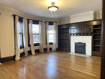 A room with a fireplace and wooden floors.
