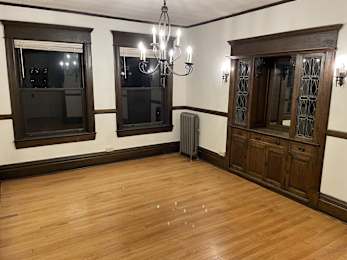 A room with wooden floors and a chandelier.