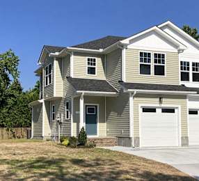 A two-story duplex with a garage on the right side.
