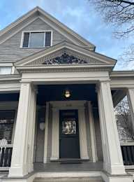 A house with a black front door and a window above it.