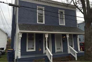 A blue house with white trim and a porch.