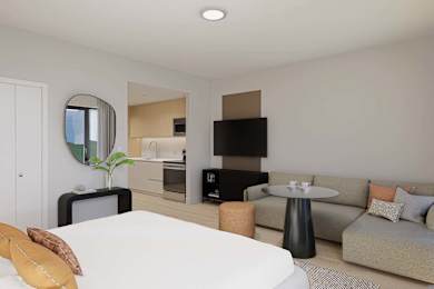 A modern living room with a white bed and a grey couch.
