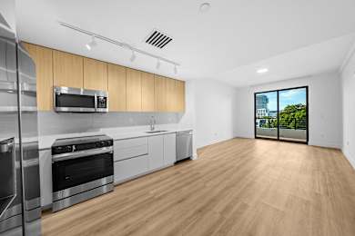A kitchen with wooden floors and stainless steel appliances.