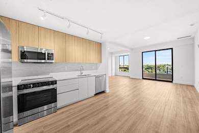 A modern kitchen with wooden cabinets and stainless steel appliances.