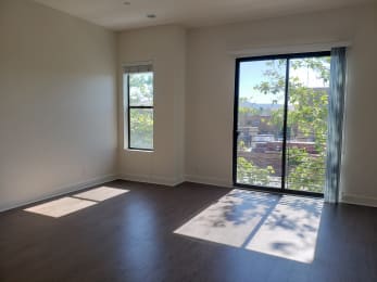 an empty living room with a sliding glass door and a view of the city  at Roundhouse Place, San Luis Obispo, 93401