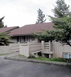 A house with a brown roof and a white fence.