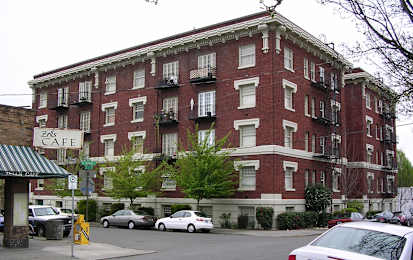 A red brick building with a green awning and a sign that says Zells Cafe.