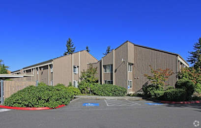 A large building with a parking lot in front.