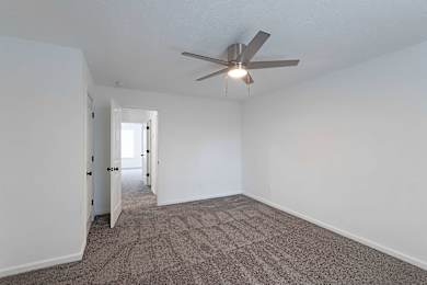 Carpeted bedroom with ceiling fan at Sterlington Apartments, Grovetown, GA