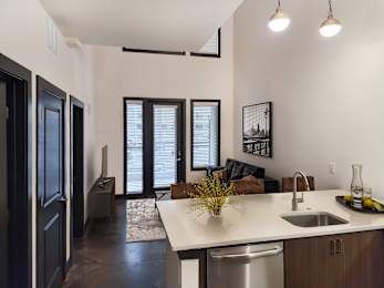 A kitchen with a white counter top and a stainless steel dishwasher.