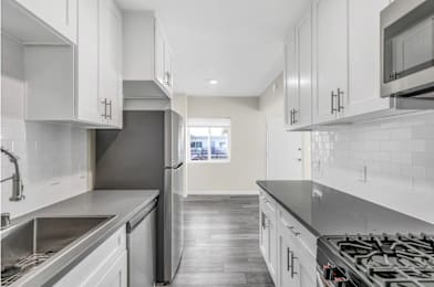 A modern kitchen with stainless steel appliances and white cabinets.