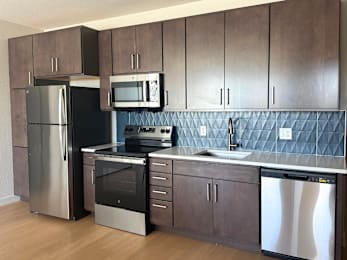 A kitchen with dark wood cabinets and stainless steel appliances.