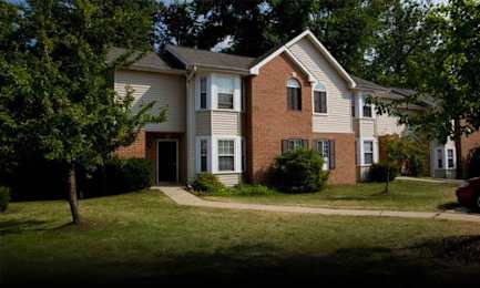 A two-story house with a red brick exterior and a white trim.