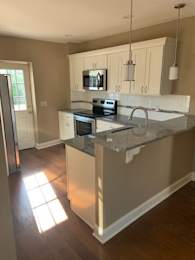 A kitchen with a granite countertop and white cabinets.