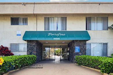 The entrance to a building with a green awning that says Porrofino.