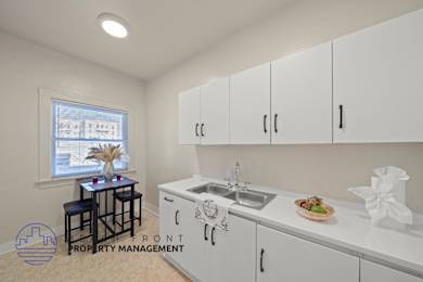 A kitchen with white cabinets and a sink.
