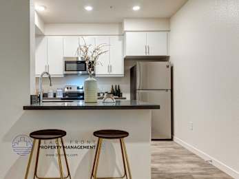 A modern kitchen with a bar stool in front of it.