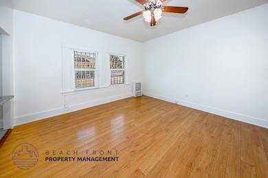 A room with wooden flooring and a ceiling fan.
