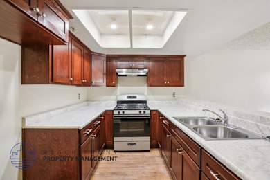 A kitchen with wooden cabinets and a stove top oven.