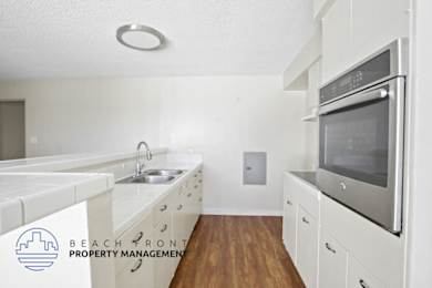 A kitchen with white cabinets and a stainless steel oven.