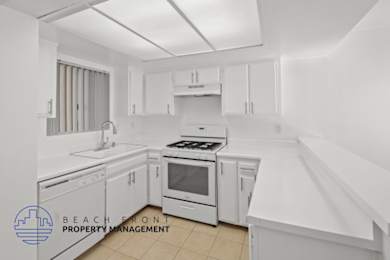 A kitchen with white appliances and cabinets.