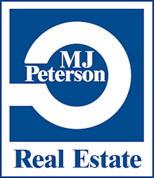 A blue and white logo for MJ Peterson Real Estate.