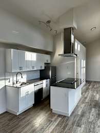 Floor Plan  A modern kitchen with a stainless steel sink and black appliances.