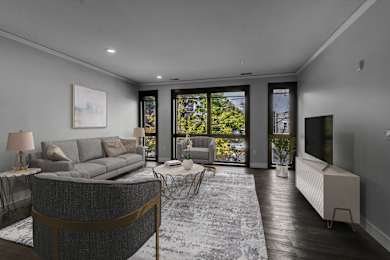 a living room with a grey couch and a tv at Nineteen North Apartments , Buffalo
