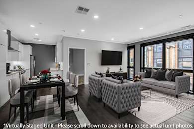 a living room with grey and white furniture and a table with chairs at Nineteen North Apartments , Buffalo, NY