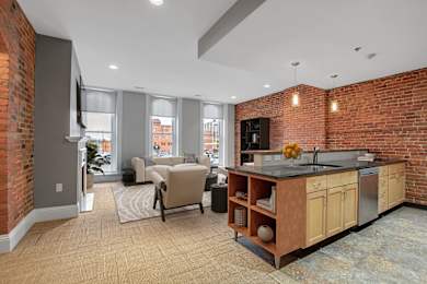 A kitchen with a brick wall and a counter top.