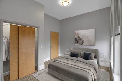 A bedroom with a large bed and a painting on the wall.
