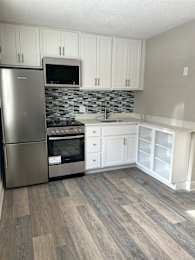 A kitchen with a stainless steel refrigerator, oven, and microwave at Briarcliff at Quechee Apartments, Quechee, 05059