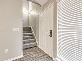 the entryway of a home with stairs and a white door at Diamond Ridge Townhomes, Oklahoma City