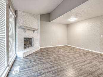 an empty living room with a fireplace and wood flooring at Diamond Ridge Townhomes, Oklahoma City, 73114