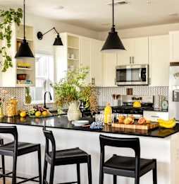 A kitchen with black countertops and white cabinets.