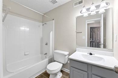 A white bathroom with a toilet, sink, and bathtub.