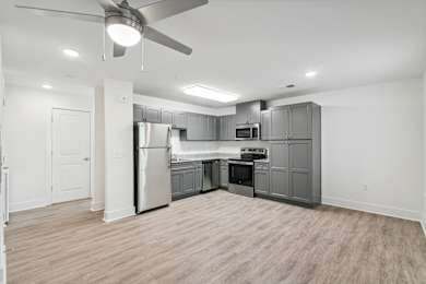 A spacious kitchen with a refrigerator, oven, and microwave at The Parker North Augusta, North Augusta, SC, 29841